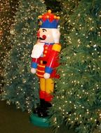 nutcracker, colorful figure at christmas trees