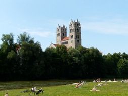 people sunbathing on meadow in view of St. Maximilian's church, germany, Munich