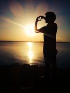 young man with a picture of a heart on a sunset background in India