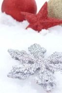 Colorful snowflake, star and ball on snow