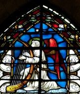 stained glass window with illustration of an angel with harp