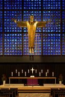 sacred altar with a golden statue of crucified jesus in church