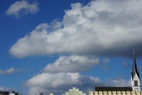 seagulls and clouds over the church spire