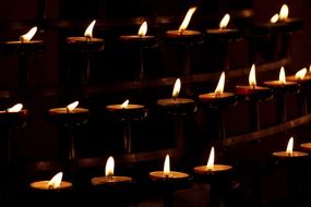 burning candles in a church in the dark