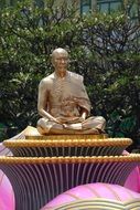 gold meditating monk statue