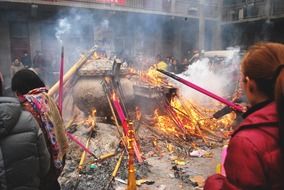 people burning incense at buddhist temple