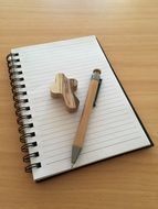 notebook, pen and wooden cross