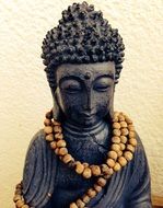 buddha statue with beads around his neck