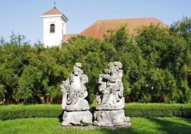stone statues in a garden near the church
