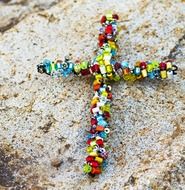 colored bead cross on a rock