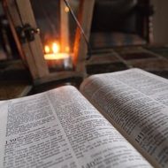 open bible near the lighting candles