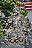 Stone statue of monk in temple in Thailand