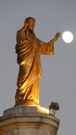 golden statue of jesus and moon