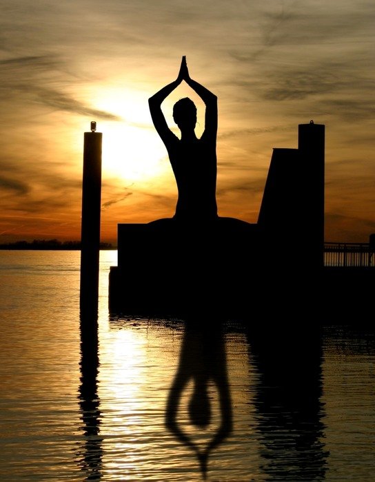 reflection in the water of a meditating figure