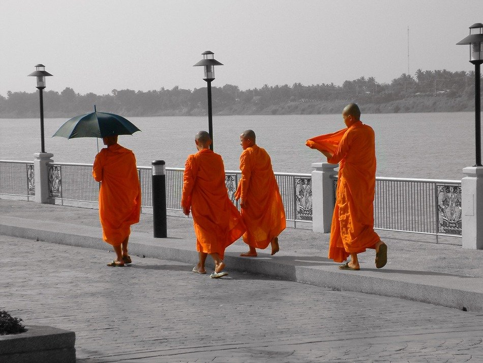 buddhist monks in orange on the waterfront