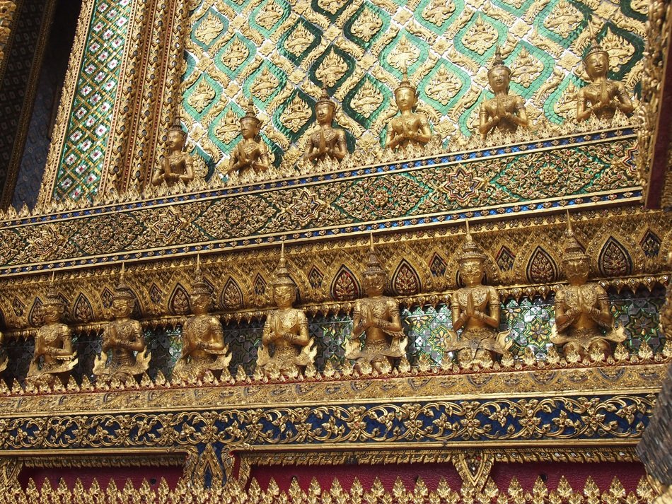 golden buddha statues on the temple wall