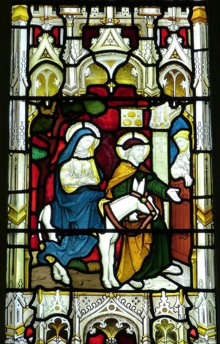 The old stained glass window with the image of Mary on the donkey