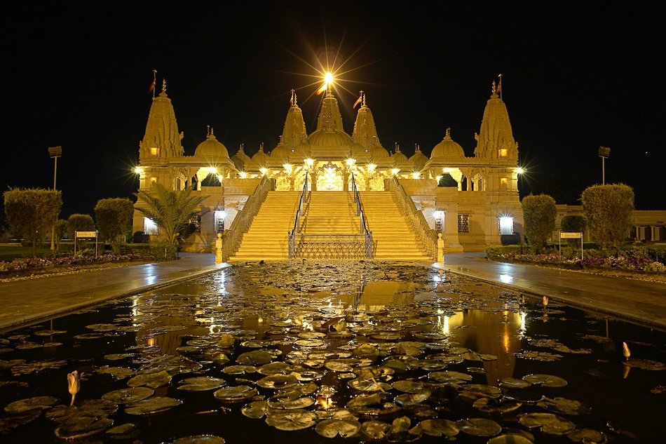 indian temple reflected in water in bright night illumination