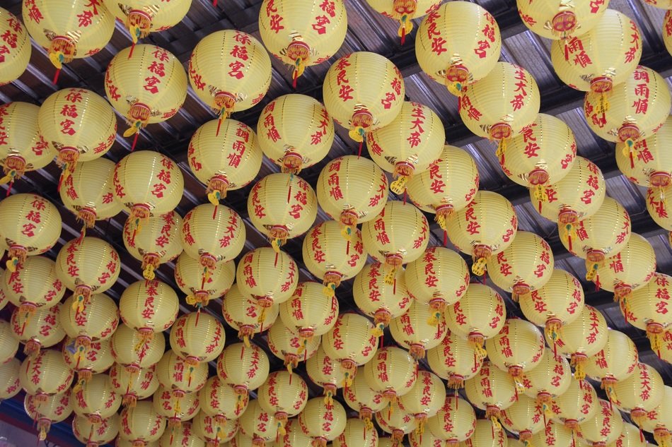 many lanterns on the ceiling in the temple