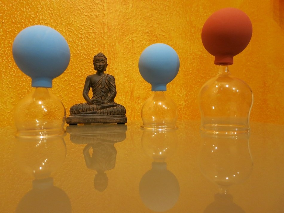 photo of cupping massage with religion of buddhism statuettes