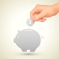 saving concept hand putting a coin into piggy bank