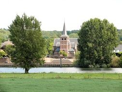 distant view of the church near the river in the village of Batenburg