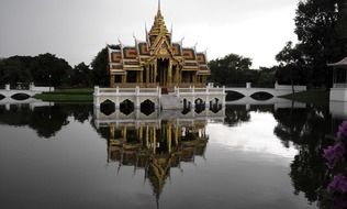 View from the water on a Buddhist temple with a white fence