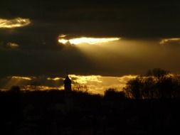 sun rays behind dark clouds