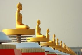 many yellow statues of buddha