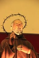 priest and crown of thorns statue