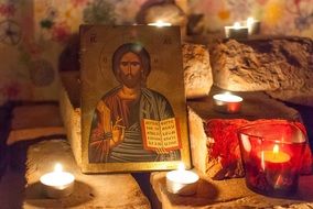 icon of jesus and burning candles in prayer space