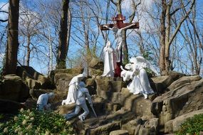 white statues near crucified christ in the park