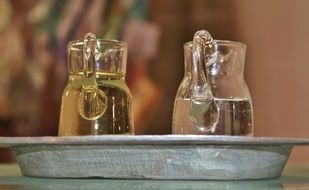 two glass jugs with water on metal plate
