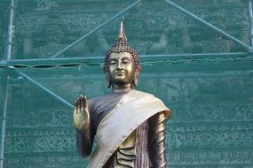 Buddha statue on the background of the green wall in Thailand