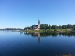 church with mirroring at blue water, summer lanscape, Sweden, arjeplog