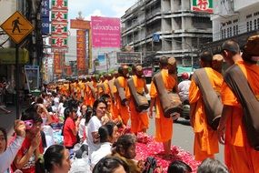 Buddhist monks walking along a path of rose petals