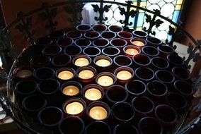 burning candles on a stand in the church