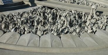 sculpture of struggling hands in white temple