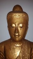 golden buddha statue near the wall