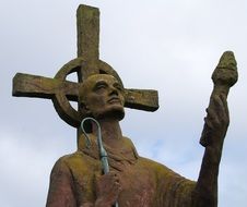 Modern statue of St. Aidan of Lindisfarne at sky, uk, england