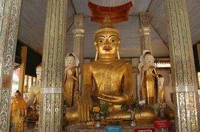 golden buddha statue near the columns