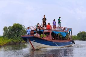 Tourists on a boat on a blue lake in cambodia