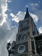 bell tower with clock at cloudy sky