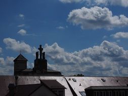 angels near the cross on the roof of the church on a sunny day