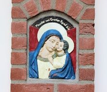 Mary and the baby fresco on a brick wall