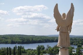 statue in the form of an angel near the lake