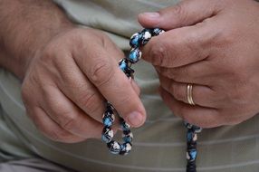prayer beads in the hands of man