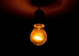 a yellow light bulb hanging from the ceiling