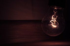 dim lightbulb shinning in the dark