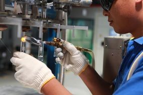 Man is doing a electric welding on a factory